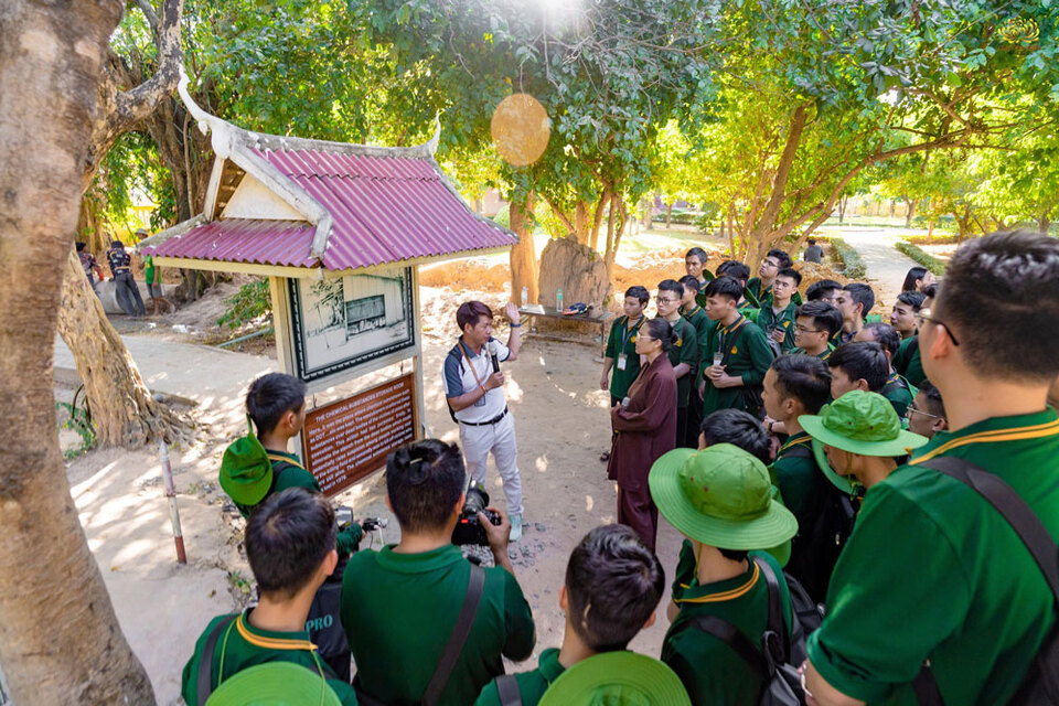 Cô Phạm Thị Yến và các Phật tử cùng lắng nghe câu chuyện lịch sử tại nơi đây qua lời kể của hướng dẫn viên.