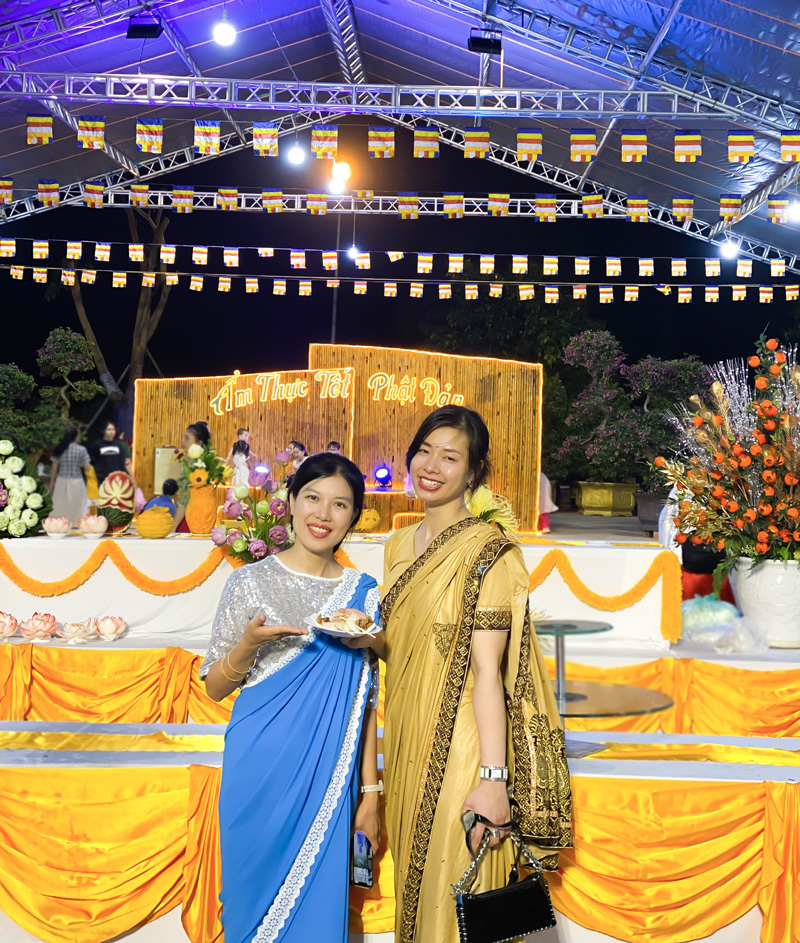 Chị Nguyễn Thị Kim Ngân (mặc sari vàng) và chị Nguyễn Thị Bắc (mặc sari xanh) chụp ảnh tại Không gian Ẩm thực Tết Phật đản