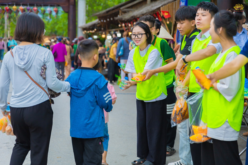 Các bạn trong CLB Tuổi Trẻ trao gửi bánh ngọt và nước uống tới nhân dân, du khách
