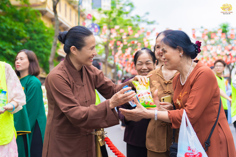 Cô Chủ nhiệm trao gửi bánh ngọt và nước tùy hỷ bà con đi chiêm bái Xá lợi Phật