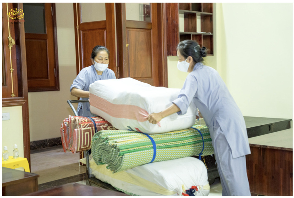 Phật tử Nguyễn Thị Thái (đứng gần cửa) cùng đạo hữu di chuyển đồ đạc từ Nhà Phật tử sang nơi ở mới