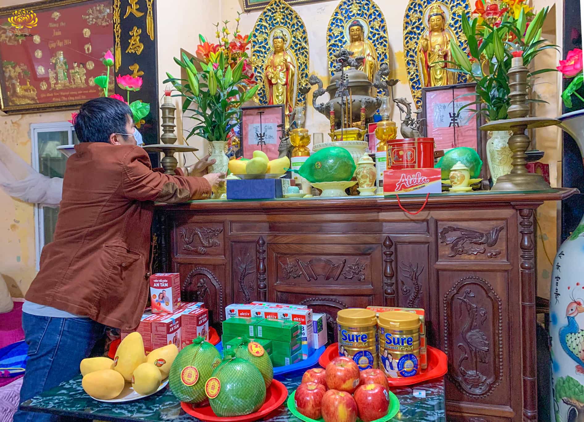 Phật tử dâng hoa, quả lên ban thờ để cúng Phật và gia tiên