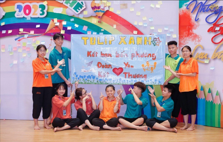 Mai Trang (áo cam, đeo kính, đứng bên trái) cùng các bạn khoe slogan - một sản phẩm mà bạn được cùng tham gia làm với cả nhóm