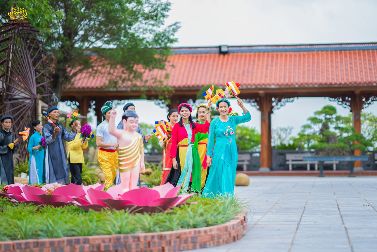 Cô Phạm Thị Yến cùng các Phật tử nhiễu quanh tôn tượng đản sinh của Ngài với cờ và hoa