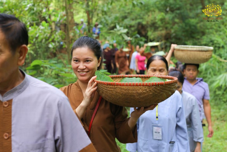   Phật tử CLB Cúc Vàng đi thành từng hàng mang thực phẩm vào rừng cúng dường chư Tăng
